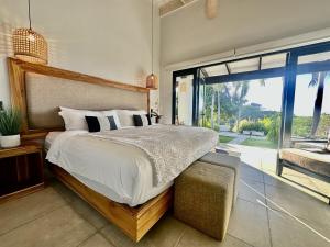 a bedroom with a large bed and a large window at New Exclusive Retreats Tamarindo 8 Bedroom Villa in Tamarindo +47 photos