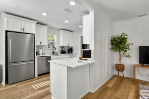 a kitchen with white cabinets and a refrigerator at It's A Vibe- less than 10mins Capital,Hospitals,FAMU,&FSU in Tallahassee