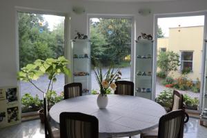 a dining room with a table with a vase of flowers at Pension Pod Šibeňákem in Strmilov