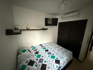 a bedroom with a bed with a quilt on it at Ciudadela Santafé De Antioquia in Santa Fe de Antioquia +13 photos