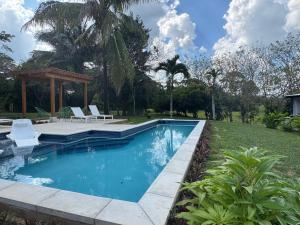 a swimming pool in a yard with a gazebo at Yumas Riverfront Lodge in San Ignacio