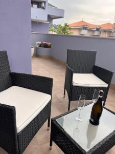 eine Flasche Wein auf einem Tisch mit zwei Stühlen in der Unterkunft Nicole in Francavilla al Mare