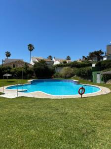 a large swimming pool in a grassy field at La Perla del Mar in Estepona