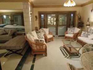a living room with chairs and a couch and a table at Exquisite Vacation Home at Zomoroda Village - North Coast in Dawwār Shindī Fannūsh