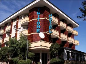 a building with a hotel sign on the side of it at Hotel Tritone in Porto San Giorgio