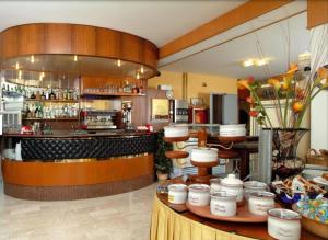 a restaurant with a bar and a counter with food at Hotel Tritone in Porto San Giorgio