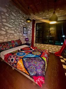 two beds in a room with colorful blankets at Villa Des Arts in Essaouira