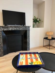 un soggiorno con tv e tavolo di Appartement Saint-Louis a Verdun-sur-Meuse