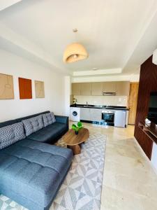 een woonkamer met een blauwe bank en een tafel bij Noria Golf Marrakech in Marrakesh