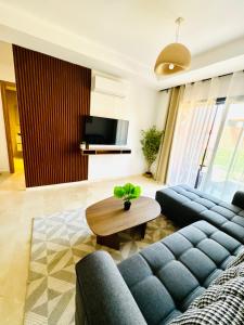 een woonkamer met een blauwe bank en een tafel bij Noria Golf Marrakech in Marrakesh