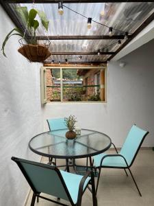 a dining room with a glass table and chairs at El Aldabón - Villa de Leyva in Villa de Leyva +25 photos