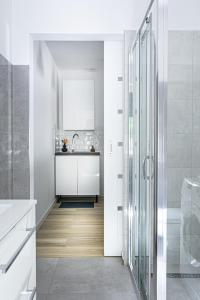 a white bathroom with a shower and a sink at Apartament TU Cichowo in Cichowo +13 photos