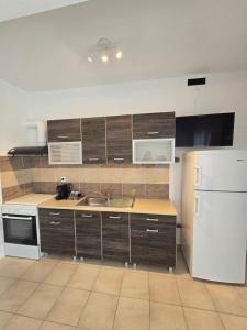 una cucina con un lavello e un frigorifero bianco di White Pebble a Città di Skiathos