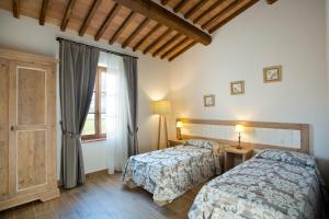1 dormitorio con 2 camas y ventana en Casale San Galgano, en Chiusdino