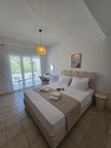 una camera da letto con un grande letto bianco e un tavolo di White Pebble a Città di Skiathos