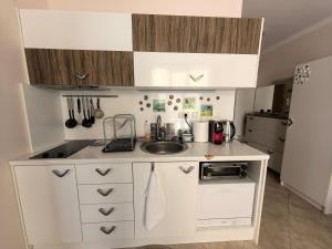 a small kitchen with white cabinets and a sink at Stela Apartment in Santa Marina Holiday in Sozopol +7 photos