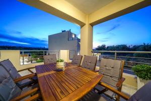 a wooden table and chairs on a balcony at Angelina Cretan Villas in Gouves