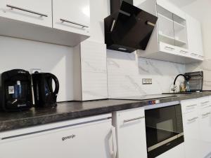 a kitchen with white cabinets and a black counter top at Beauty Haus im Zentrum in Bad Sooden-Allendorf
