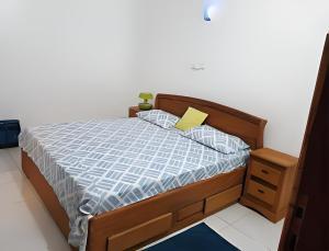 a bedroom with a wooden bed with a yellow pillow at Villa Privée in Abomey-Calavi