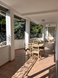 a porch with a table and chairs and windows at Montenegro Seaside Lux Apartment in Petrovac na Moru