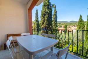 a white table and chairs on a balcony with trees at Villa Consani Charming House by Varental in Porto Ercole