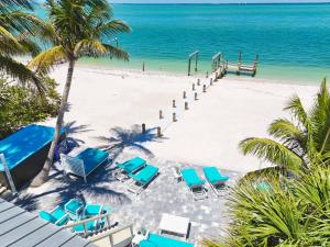 una playa con tumbonas azules y el océano en BeachFront Luxury island Home, en Captiva