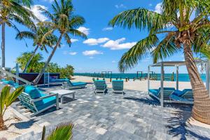Una playa con sillas y palmeras y el océano. en BeachFront Luxury island Home, en Captiva