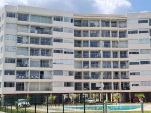 un edificio de apartamentos con piscina frente a él en Hermoso Apartamento con Vista al Lago, en Paipa