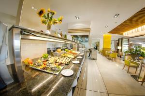 a buffet line with food on it in a restaurant at Premier Fort Beach Apartment with Pool & Sea View in Sveti Vlas +16 photos