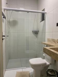 a bathroom with a toilet and a glass shower at Hotel Soares in Anapurus