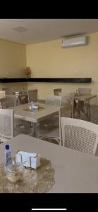 a room with tables and white chairs and a table and chairsktop at Hotel Soares in Anapurus