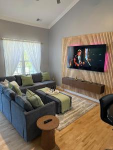 a living room with a blue couch and a tv at Ground-level bed bath house1mi to the beach sleep8 in Long Branch