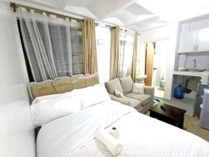 a bedroom with a large white bed and a couch at Cities bnbs in Gatunga