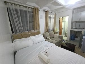 a bedroom with a large white bed and a couch at Cities bnbs in Gatunga