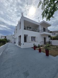 una grande casa bianca con un vialetto d'accesso di White Pebble a Città di Skiathos
