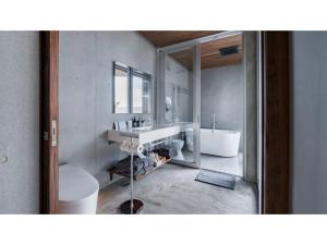 a bathroom with a sink and a tub and a mirror at Tanegashima Araki Hotel Bekkan - Vacation STAY 57000v in Nishinoomote