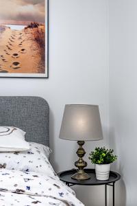 a bedroom with a bed and a table with a lamp at Apartament TU Cichowo in Cichowo