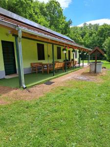 a building with benches and tables on the side of it at Garamszegi Szajki Vendégház in Hosszúpereszteg