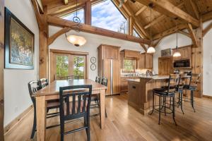 Una cocina con una gran mesa y sillas de madera. en Wolf Ridge Lodge, en Boone