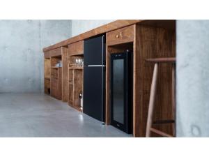 a kitchen with wooden cabinets and a black refrigerator at Tanegashima Araki Hotel Bekkan - Vacation STAY 57003v in Nishinoomote
