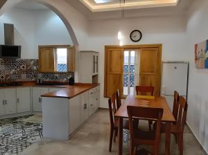 a kitchen with a table and a refrigerator at Villa Magnifique in Abomey-Calavi
