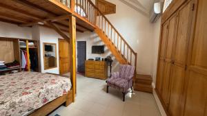 a bedroom with a bed and a wooden staircase at Villa Magnifique in Abomey-Calavi