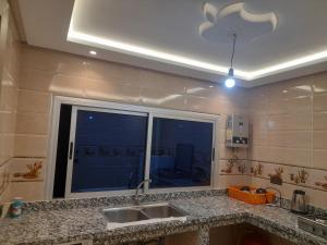 a kitchen with a sink and a large window at diki ksar sghir in Oulad Akkou