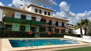 ein großes Haus mit einem davorliegenden Swimmingpool in der Unterkunft Casa rural acogedora con chimenea y vistas al atardecer in Villanueva de Algaidas
