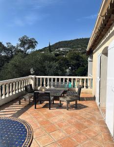 a patio with two benches and a table on a balcony at Villa de caractère! Sereine, piscine, plages 5mns! in Port Grimaud