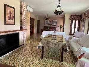 ein Wohnzimmer mit Tisch und Kamin in der Unterkunft Casa rural acogedora con chimenea y vistas al atardecer in Villanueva de Algaidas