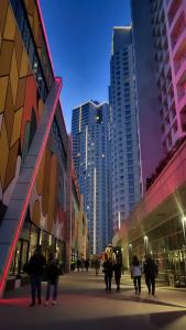 a group of people walking in a city with tall buildings at Stylish 28F Gym Free Pkg Secured in Skopje