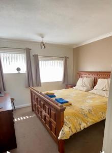 a bedroom with a large bed with a yellow comforter at Detached Home Close to the Beach Newquay in Saint Columb Minor