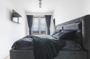 a bedroom with a large bed with a large window at Stylish 28F Gym Free Pkg Secured in Skopje +50 photos