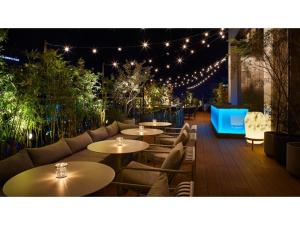 a patio with tables and chairs and lights at night at THE KNOT HIROSHIMA - Vacation STAY 20562v in Hiroshima